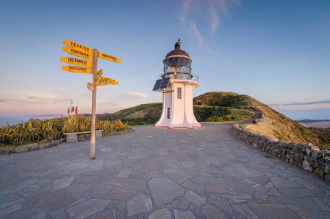 International signpost at the lighthouse at Cape Reinga in evening mood