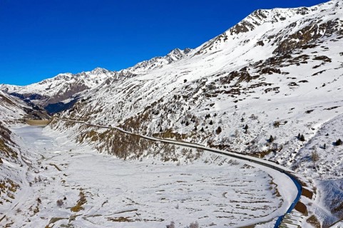 Covered country road on the snow-covered Lac des Toules reservoir in front of the Great St. Bernhard Tunnel