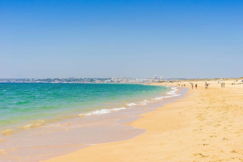 People relaxing on the beach next to Armacao de Pera