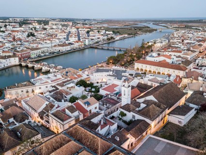 City view with roman bridge over Gilao river in old fishermen's town in the evening light