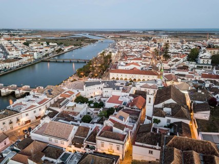 City view with roman bridge over Gilao river in old fishermen's town in the evening light