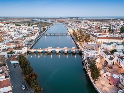City view with roman bridge over Gilao river in old fishermen's town in the evening light