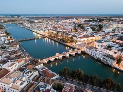 City view with roman bridge over Gilao river in old fishermen's town in the evening light