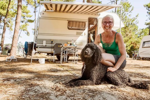 Woman squats laughing with her dog