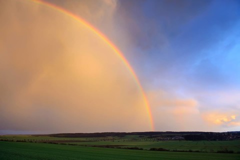 Double rainbow over agricultural landscape
