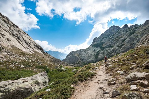 Young man hiking on a trail through the Golo Valley Nature Park of Corsica