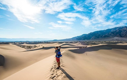 Young man photographing sand dunes