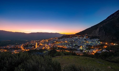 View of illuminated city Chefchaouen at sunset
