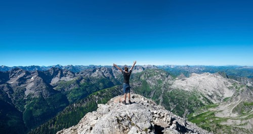 Hiker stretches arms into the air