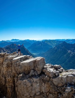 Hiker reaches arms into the air