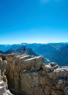 Hiker jumps and stretches arms into the air
