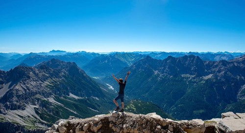 Hiker stretches arms into the air