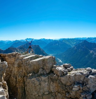 Hiker jumps and stretches arms into the air