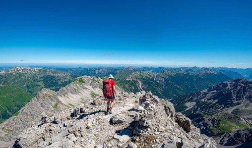 Hiker descending from the summit of the Hochvogel