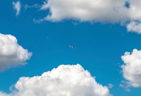 Electric airplane flying in front of a blue cloudy sky