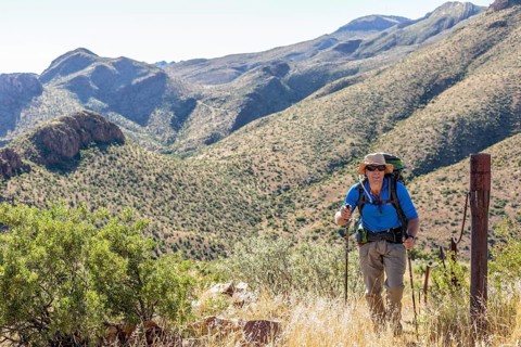 Hiker with backpack and sticks