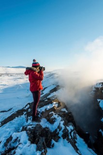 Woman standing at divergent tectonic boundary between North American and Eurasian plates