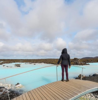 Tourist on a wooden bridge at the Blue Lagoon near Gratdavik