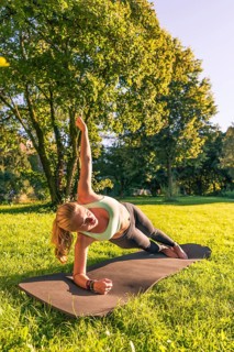 Young woman in sportswear doing side plank