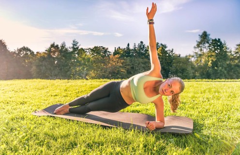Young woman in sportswear doing side plank