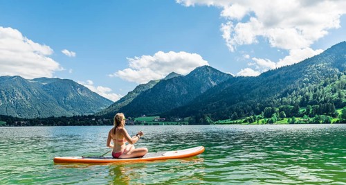 Young woman sitting on a Standup-Paddle Board or SUP