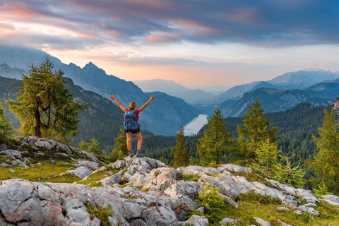 Hiker stretches arms into the air