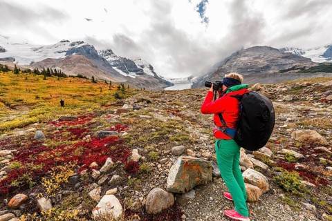 Young woman photographs barren landscape