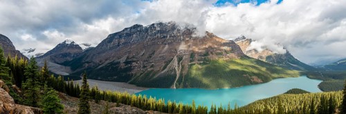Glacier valley and glacier with turquoise glacial lake surrounded by forest