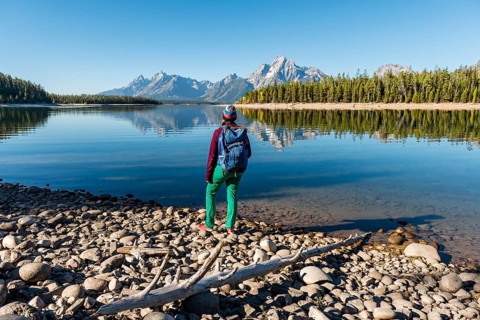 Young woman with rucksack standing on shore