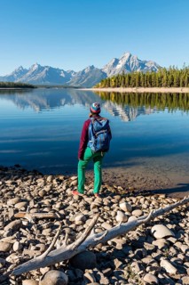 Young woman with rucksack standing on shore