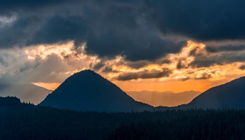 Hilly wooded mountain landscape at sunset with dramatic clouds