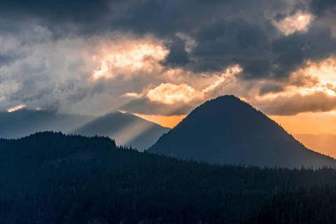 Hilly wooded mountain landscape at sunset with dramatic clouds