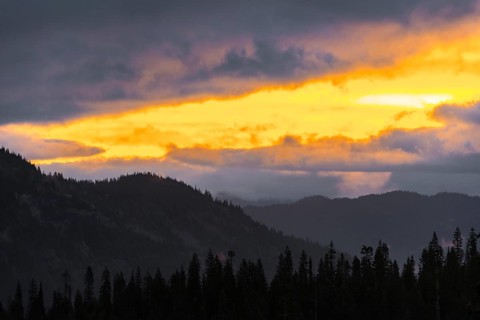 Hilly wooded mountain landscape at sunset with dramatic clouds