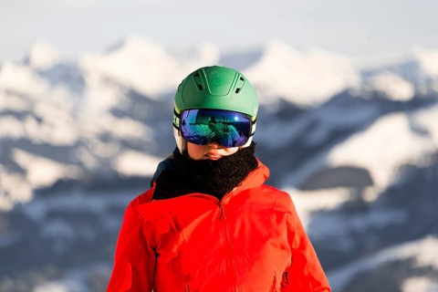 Female skier with ski helmet and ski goggles looks into the camera