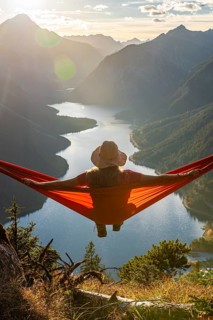 Woman with a sun hat sitting in an orange hammock