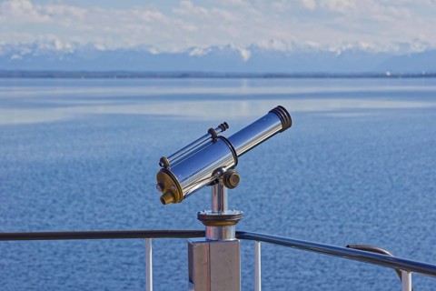 Binoculars with view to the snow-covered alpine peaks