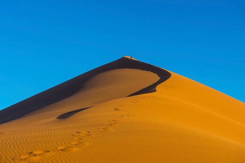 Woman walking up the giant sanddune Dune 45