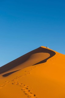 Woman walking up the giant sanddune Dune 45