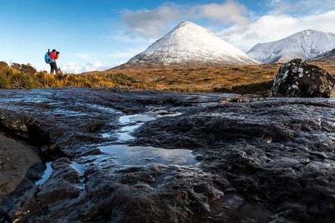 Photographer with snow-covered peaks of the Cullins Mountains
