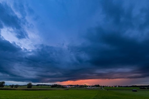 Thunderstorm sky with small village and meadows landscape