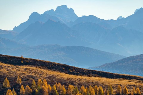 Hikers on autumnal ridge with Peitlerkofl in the background