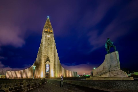 Illuminated church Hallgrimskirkja with monument of Leif Eriksson