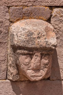 Stone head in wall of Kalasasaya Temple (place of standing stones) with monoliths from the pre-Inca period