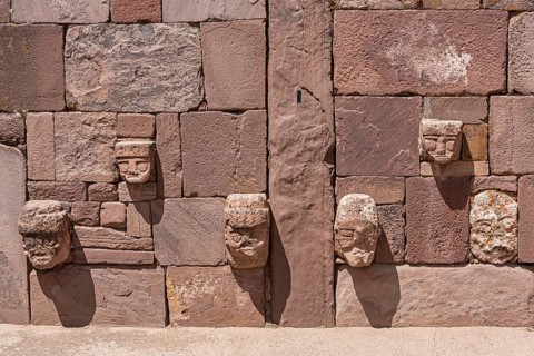 Stone heads in wall of Kalasasaya temple (place of standing stones) with monoliths from pre-Inca period