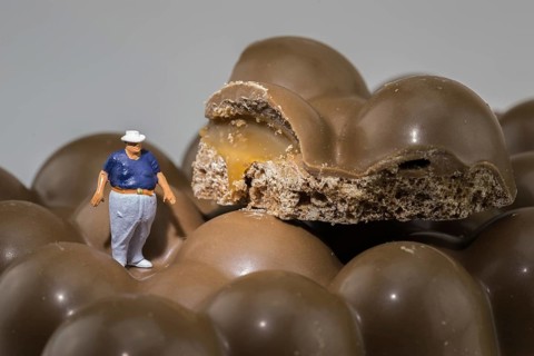 Fat man stands on chocolate