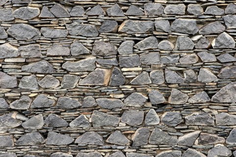Wall of layered ground-down basalt stones and slates