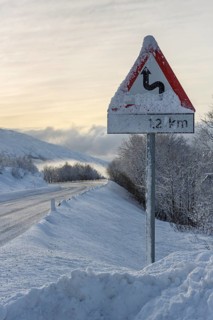 Wintry road with warning sign