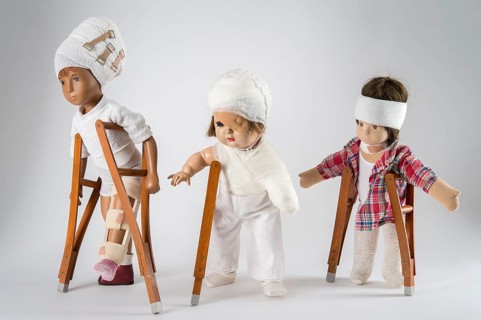Three dolls walking with crutches