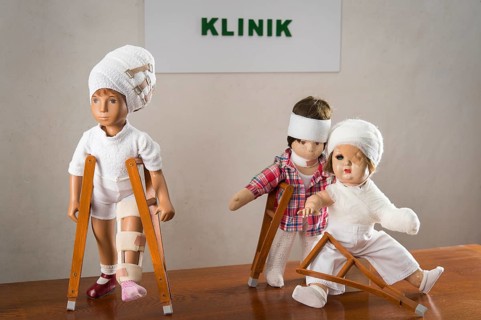 Three dolls walking with crutches