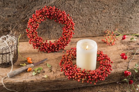 Two small autumn wreaths on wooden plate bonded with rosehip (Rosa canina)